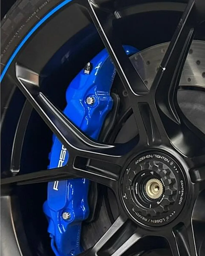 Finished blue caliper behind the wheel, mounted on the car